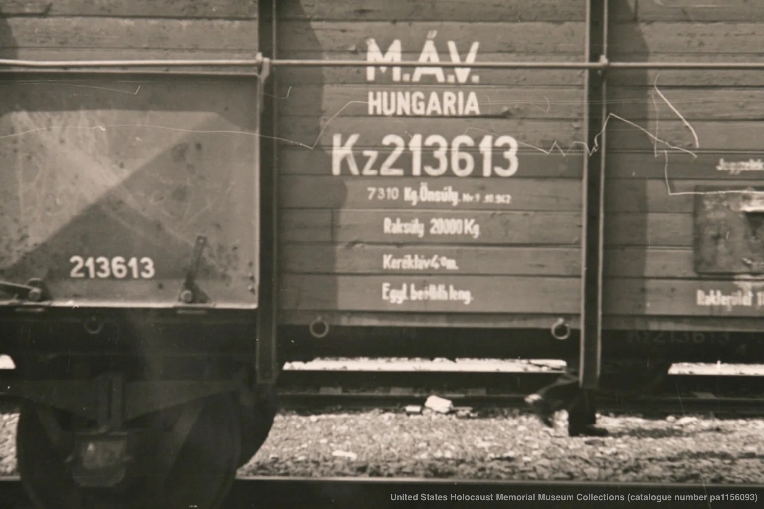 A 1945 archival photograph of a wooden freight car from the Hungarian Gold Train parked in Werfen, Austria, showing the painted identification 'MAV Hungaria' on its side.
