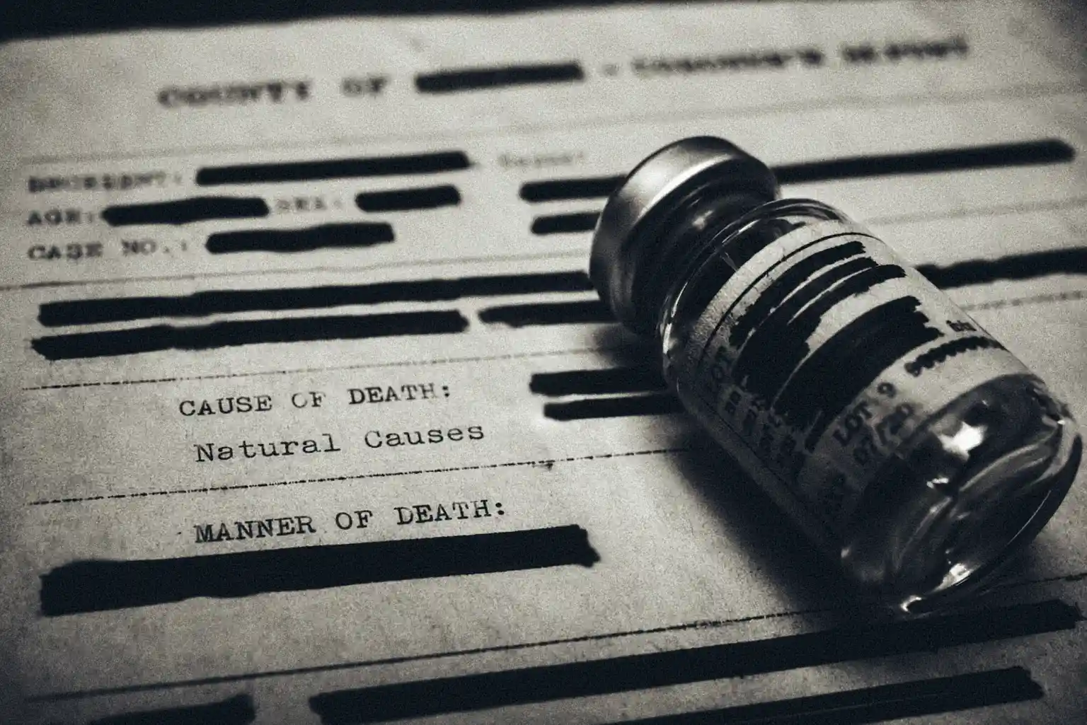 A black and white close-up of a medical glass vial resting on a heavily redacted typewritten coroner's report, with only the words 'Natural Causes' visible, illustrating the clinical contradiction at the 1993 Bridgend inquest into the death of Jennifer Gibbons.