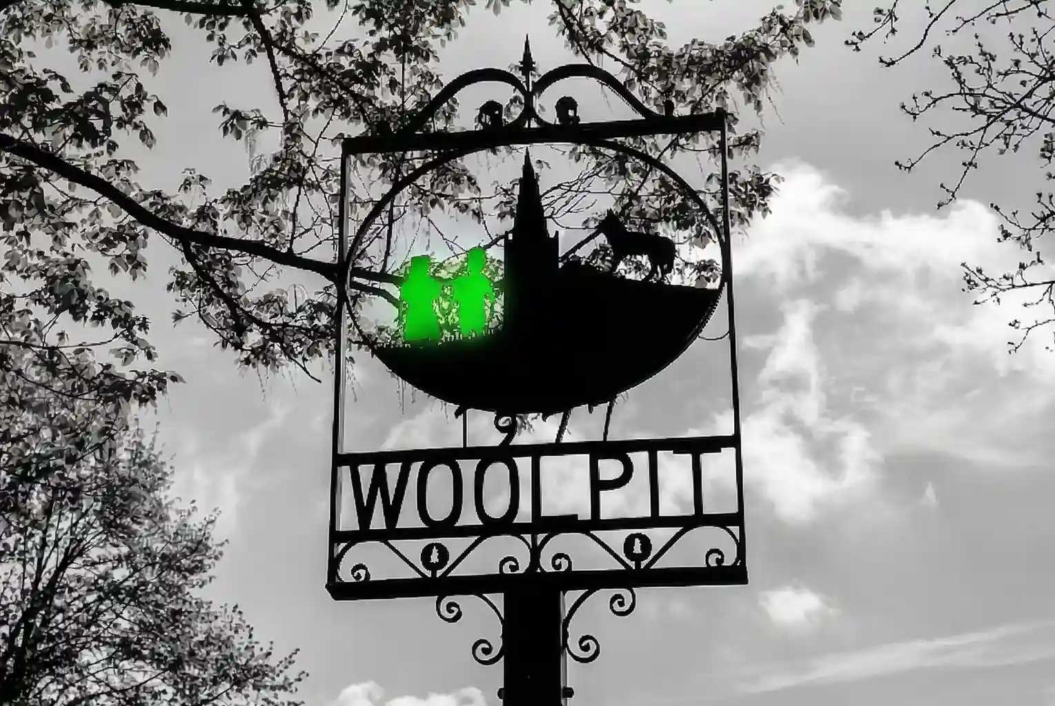 The wrought-iron Woolpit village sign in Suffolk, depicting the legendary green children and a wolf.